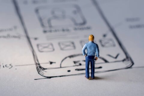 Un muñeco en miniatura mirando un esquema UX
